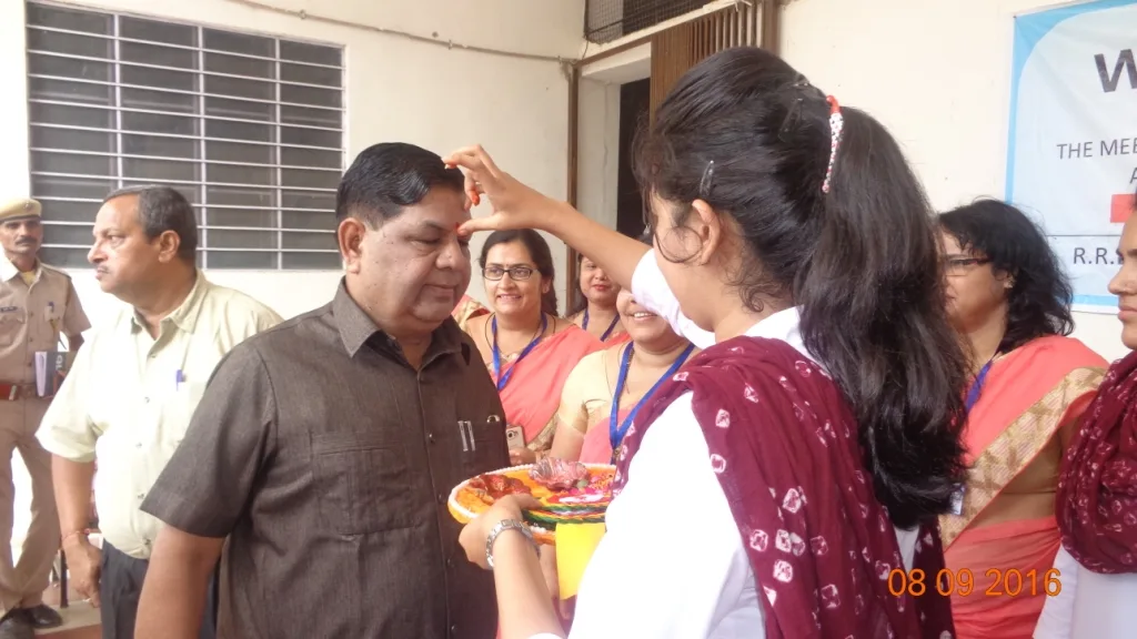 Welcome ceremony — student applying tilak to distinguished guest, 2016
